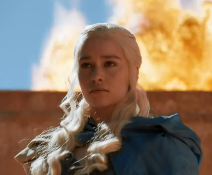 Daenerys looking determined while a fire rages behind her