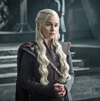 Daenerys stands with her hands clasped in front of her.